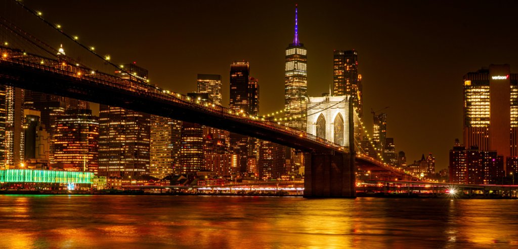 Best places to visit in New York Walking across the historic Brooklyn Bridge with views of the Manhattan skyline