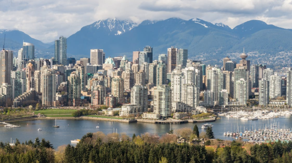 Vancouver skyline reflected in Burrard Inlet at golden hour with snow-capped mountains — best places to visit in Vancouver